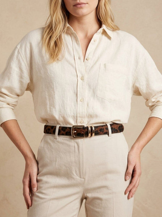 Model trägt schmalen Leoparden-Gürtel mit goldfarbener Schnalle zu cremefarbenem Outfit