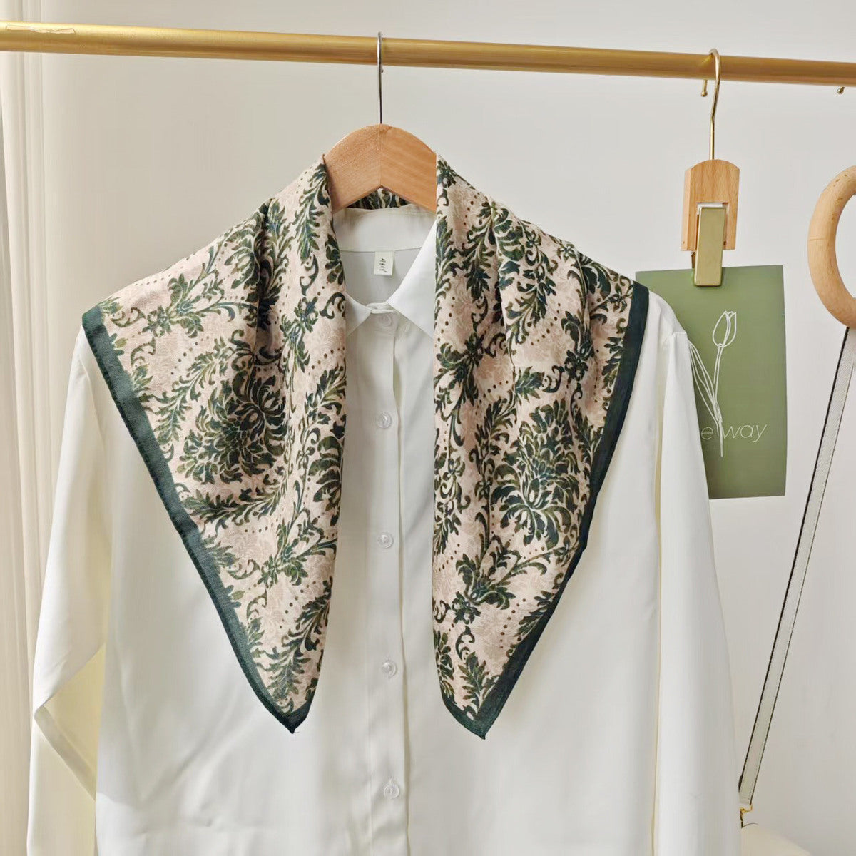 Grünes florales Viskosetuch mit dunklem Rand auf weißer Bluse