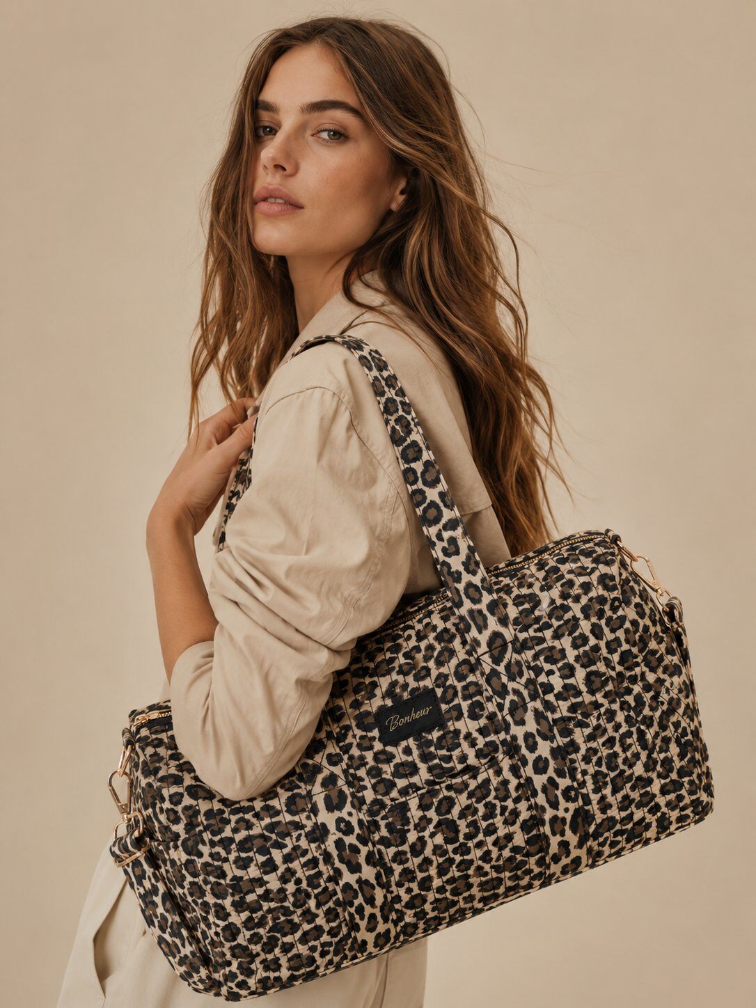 Model trägt die gesteppte Wochenendtasche mit Leopardenmuster über der Schulter